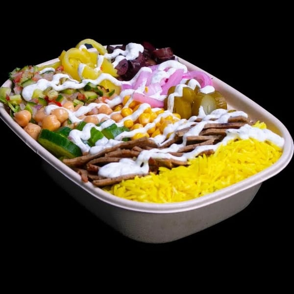 A colorful Build-A-Pita & Pizza bowl with yellow rice, meat, chickpeas, corn, and various pickled vegetables.